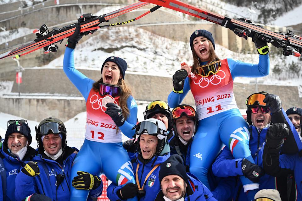 احتفلت إيطاليا الحائزة على الميدالية الفضية صوفيا جوجيا (على اليسار) والحائزة على الميدالية البرونزية الإيطالية ناديا ديلاغو (على اليمين) مع فريقهما خلال حفل فوز السيدات على المنحدرات في دورة الألعاب الأولمبية الشتوية في بكين 2022 في يانكينغ الوطنية مركز التزلج الألبي في يانكينغ ، 15 فبراير 2022 (تصوير جيف باشود / وكالة الصحافة الفرنسية) (تصوير جيف باشود / وكالة الصحافة الفرنسية عبر غيتي إيماجز)